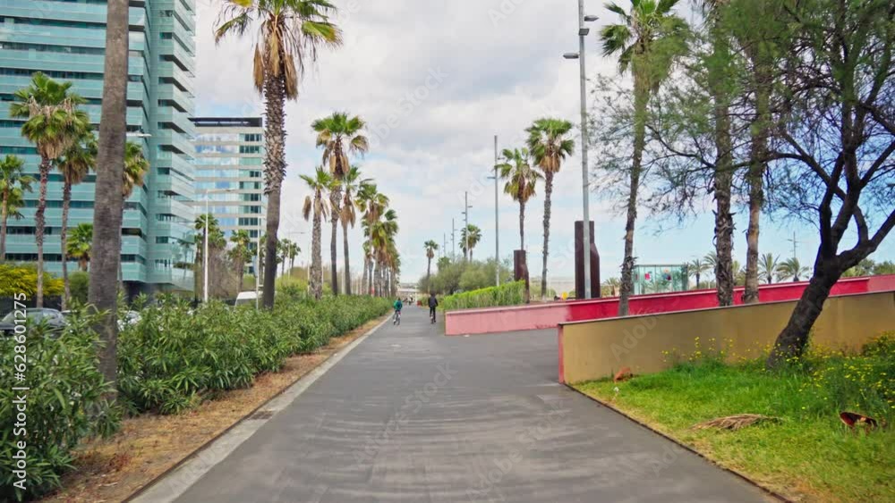 A skateboarder riding down a city street surrounded by towering buildings A skateboarder riding down a city street surrounded by towering buildings