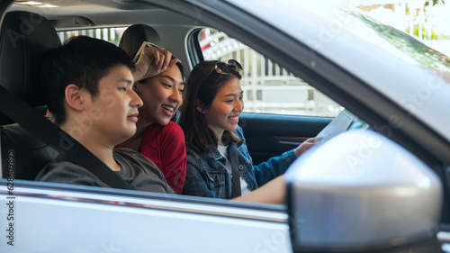 Asian friends check map to find location before driving suv car