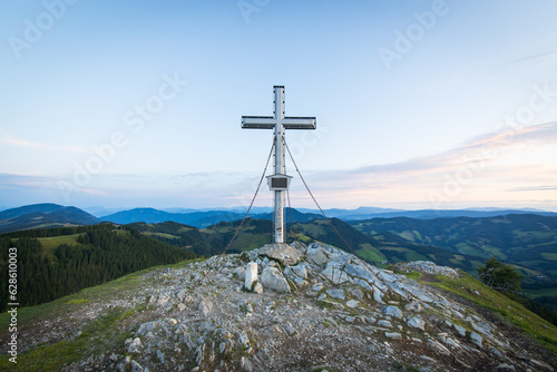 Summit cross on a rocky peak of the mountain Plankogel in Austria