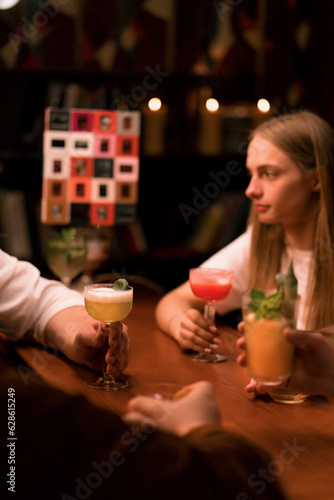 a group of friends in a bar drinking cocktails and having fun Toasting cocktails Glasses in a club bar close-up 