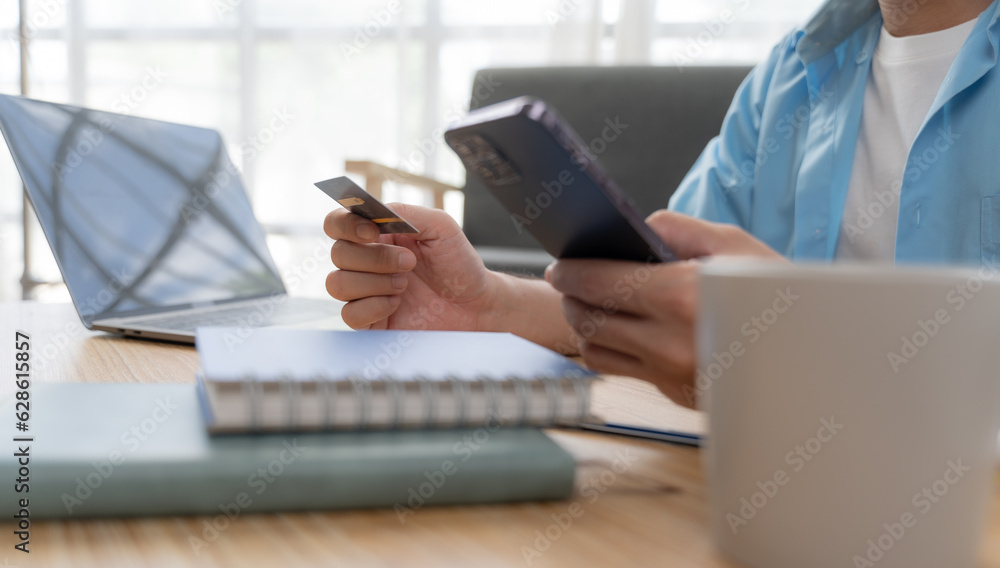 Man hands using laptop and holding credit card with social media as Online shopping concept in morning light Man hands using laptop and holding credit card with social media as Online shopping concept in morning light