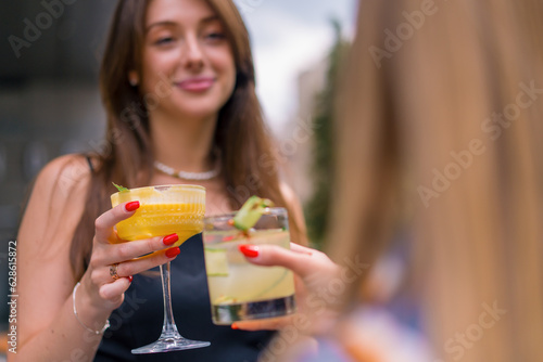 Close-up of friends toasting with cocktails on the summer terrace in the a club s bar