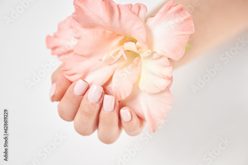 Female hand with pink manicure and flower