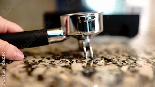 Close-up view hand puts on the table portafilter. Slow motion