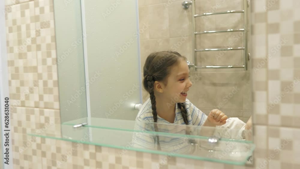 Portrait of happy cute siblings brushing teeth near mirror in bathroom
