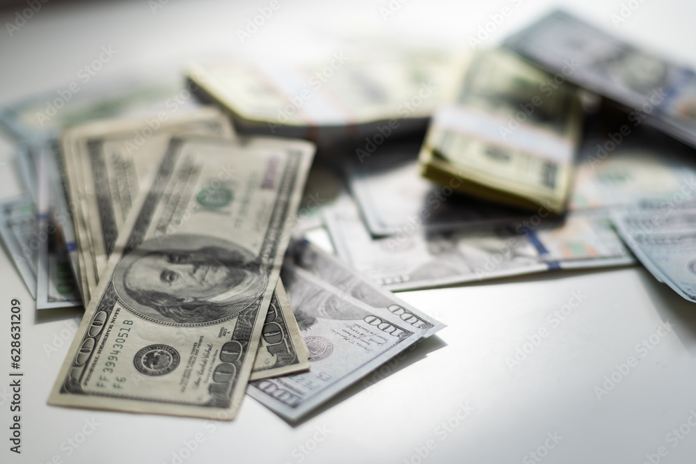 One hundred dollars pile as background. Many American dollars are slowly falling onto the table. Man throws green american money. American financial system. One hundred dollars pile as background. Many American dollars are slowly falling onto the table. Man throws green american money. American financial system.