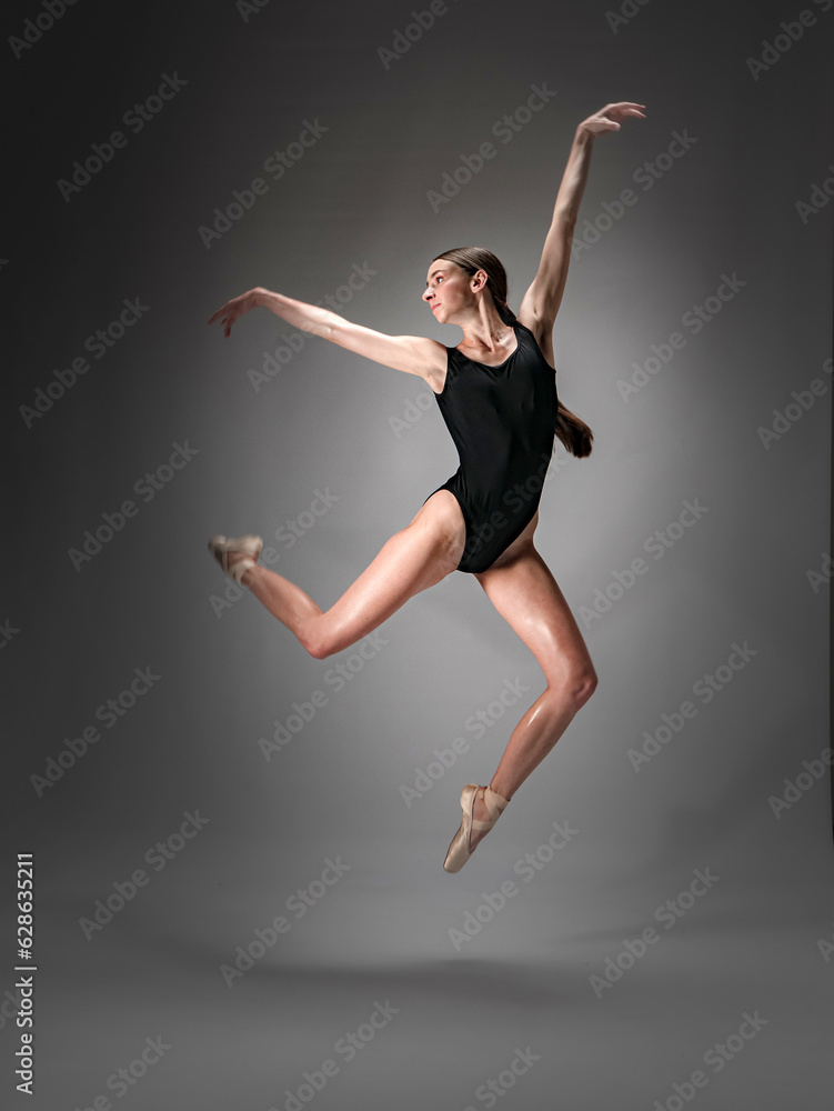 Young slender model-looking dancer with long hair in black tight-fitting dancewear in action
