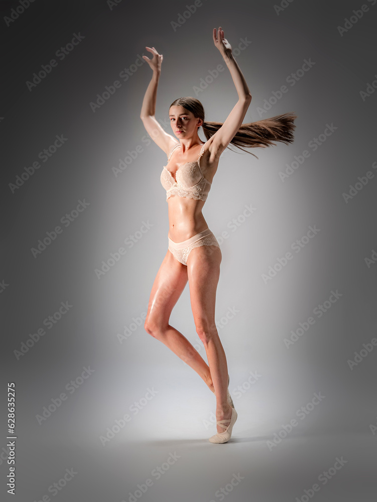 Young slender model-looking dancer with long hair in beige tight-fitting dancewear  in action