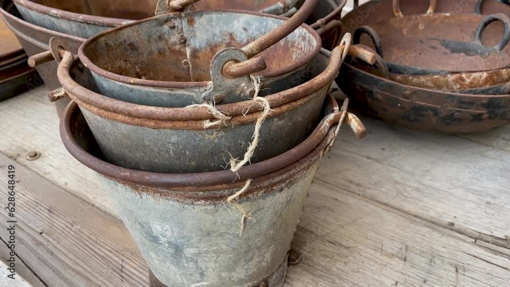 Old rusty steel utensils, basins and buckets of different shapes and sizes Old rusty steel utensils, basins and buckets of different shapes and sizes