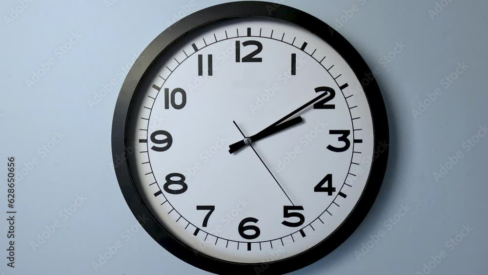 Closeup of White Clock Face on white wall clock, arrows show 02:10 or 14:10 Closeup of White Clock Face on white wall clock, arrows show 02:10 or 14:10