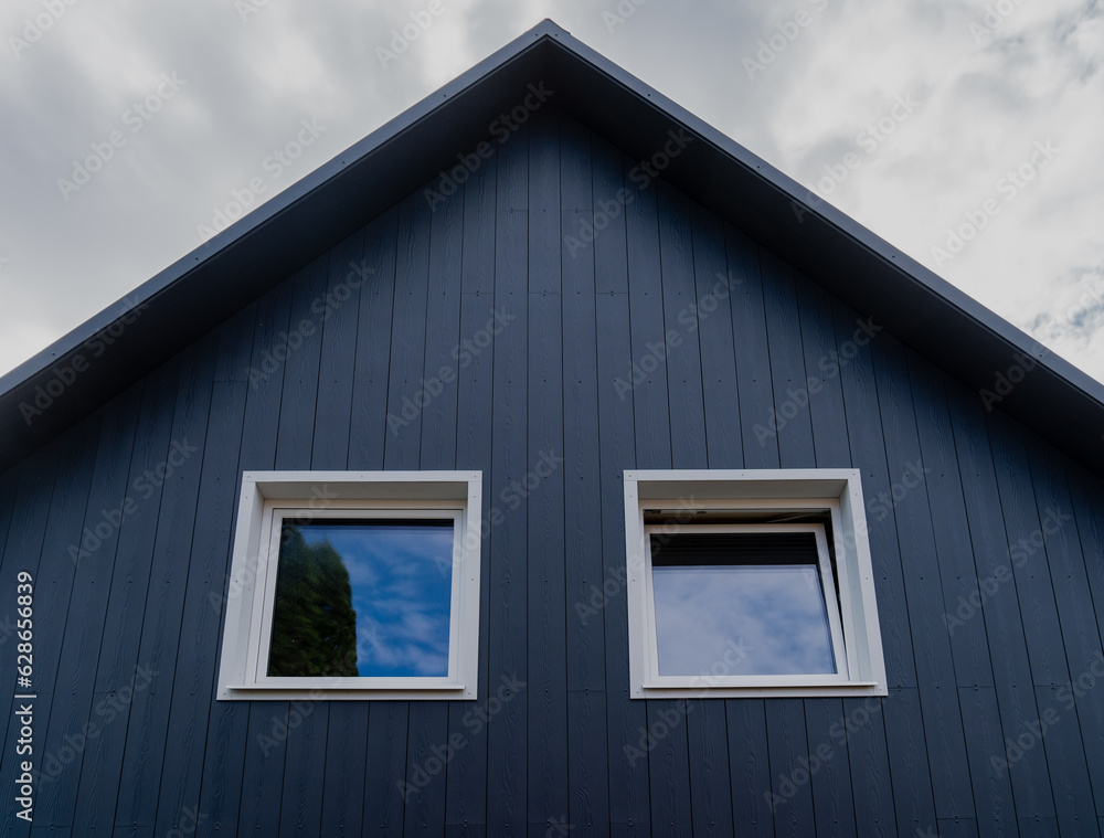 Modern grey wooden exterior building with two plastic white windows Modern grey wooden exterior building with two plastic white windows