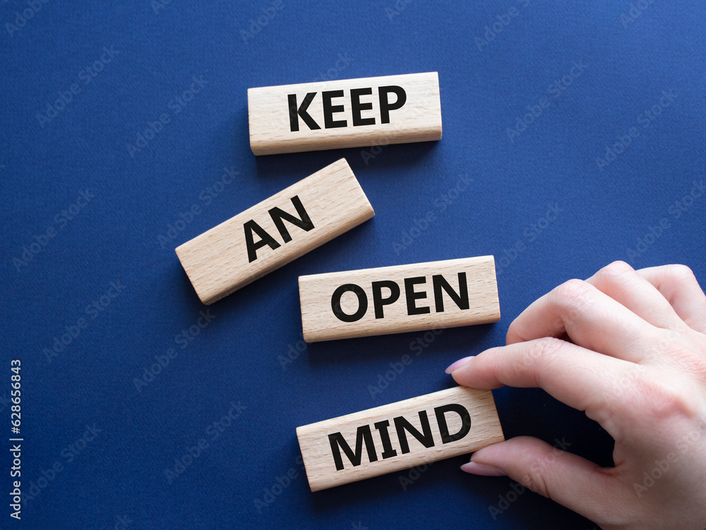 Keep an open mind symbol. Wooden blocks with words Keep an open mind. Businessman hand. Beautiful grey green background. Business and Keep an open mind concept. Copy space.