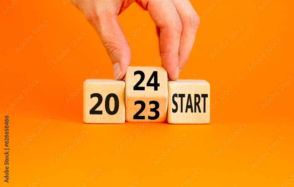 2024 start new year symbol. Businessman turns a wooden cube and changes