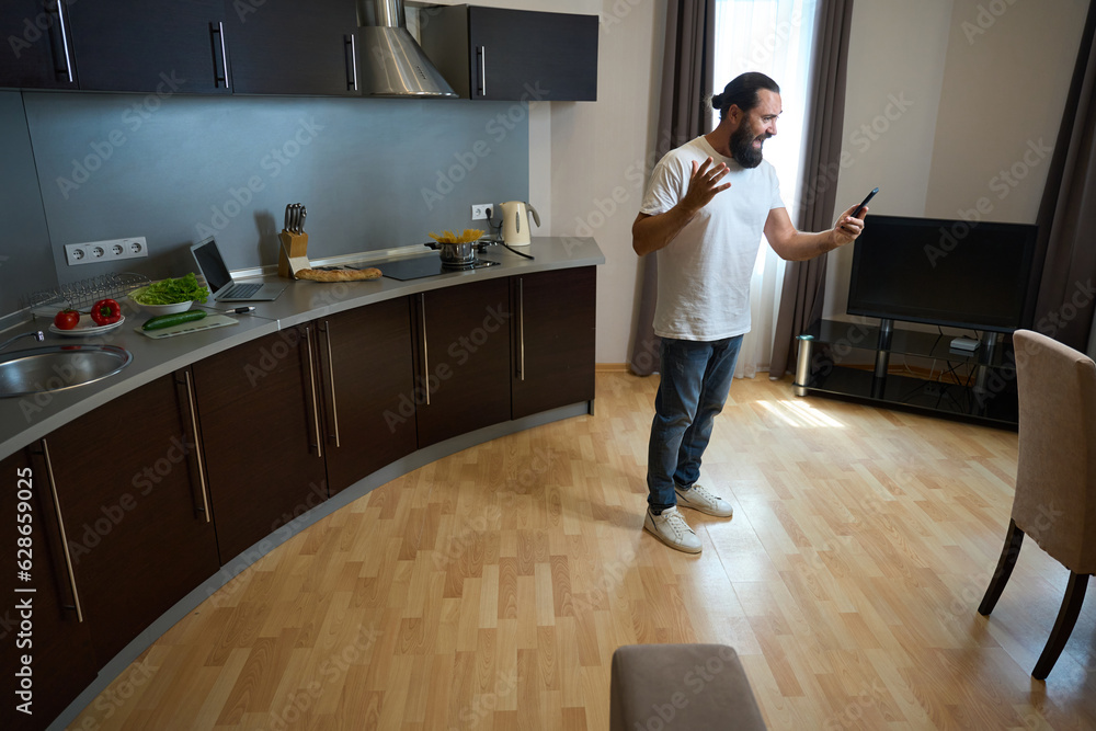 Man in casual clothes communicates online on a mobile phone