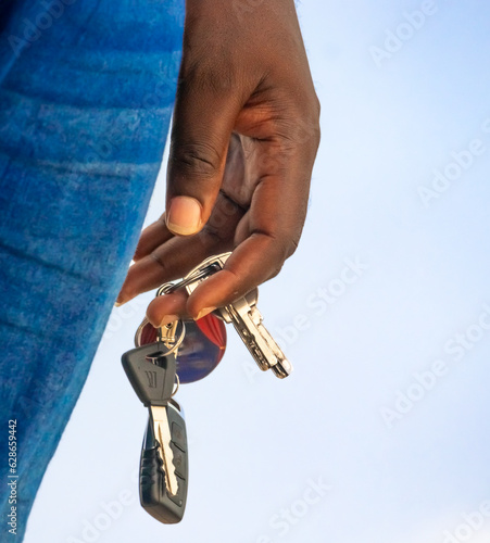 Evocative depiction of a man proudly displaying a vehicle key, signifying his access and ability to drive..