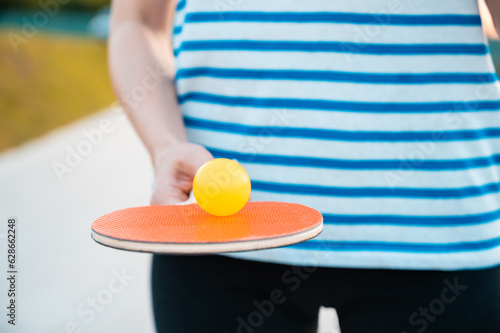 Woman holding ping pong paddle  table tennis paddle with ball. © Evgeniya