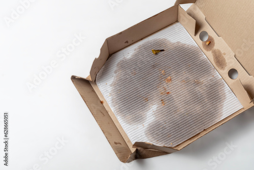 Empty pizza box with grease stains isolated on white. Top view. Copy space.