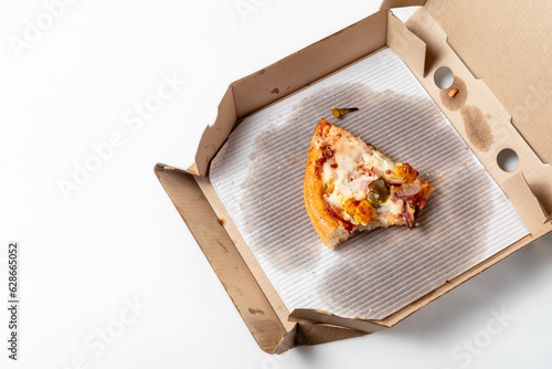 Leftover pizza in an open cardboard pizza box isolated on white background. Top view