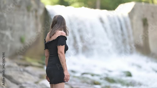 Bella Donna sul fiume con tacchi alti e abito estivo video in 8k photo