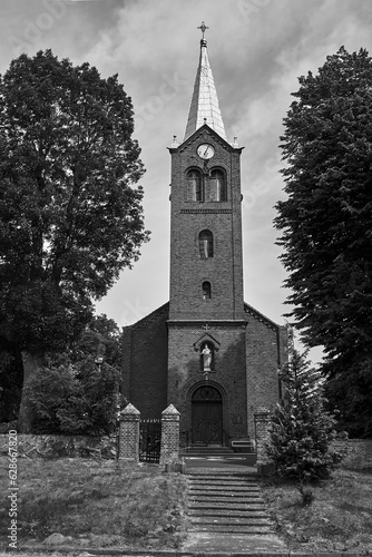 The historic tower of the Gothic red brick church in the village of Sokola Dabrowa photo