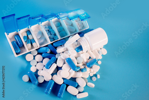 Blue-white pills and capsules in weekly pill organizer