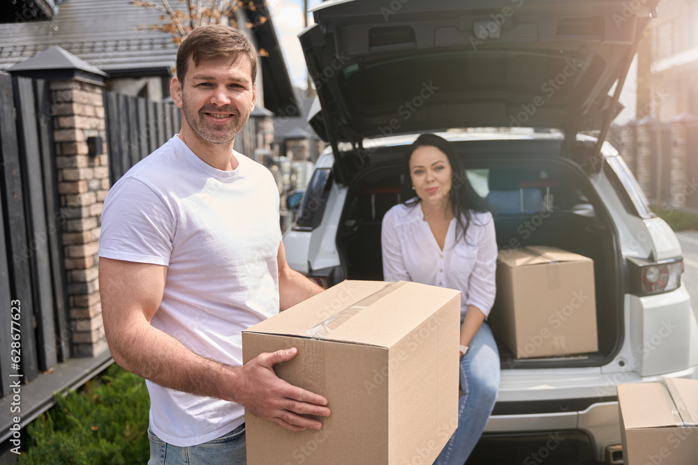 Man holding a box in front of his wife Man holding a box in front of his wife