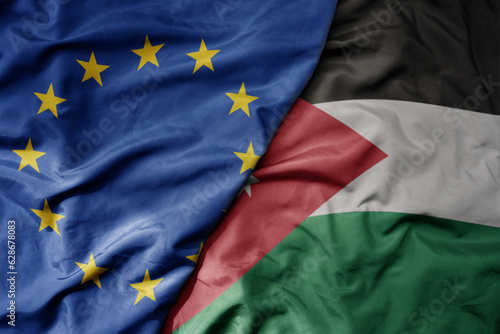 big waving realistic national colorful flag of european union and national flag of jordan .