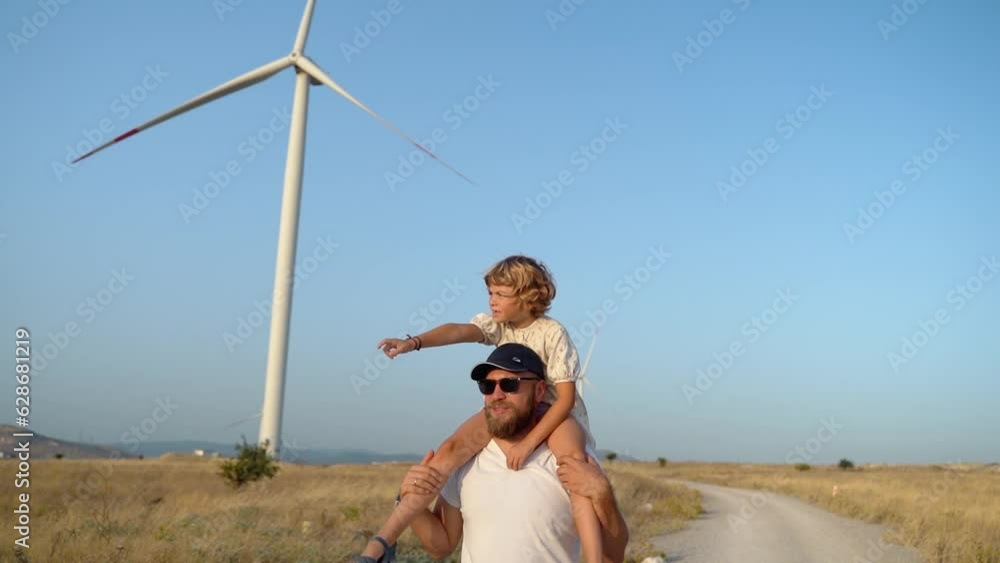 Man Carrying his Child Girl on His Shoulders and Walking in a Wind farm ...