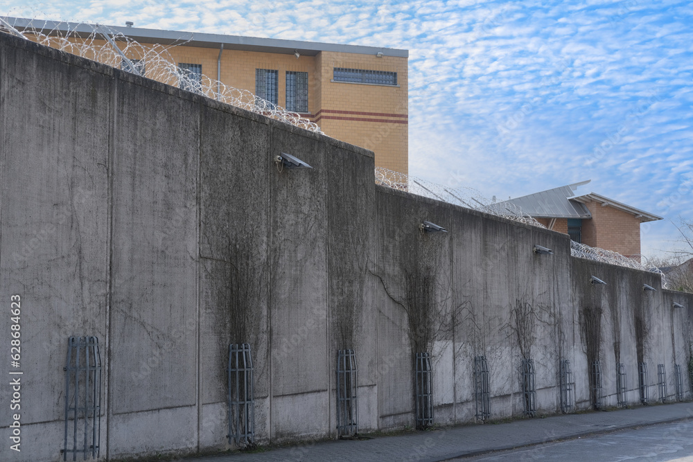 high concrete fence, barbed wire fence on top, pre-trial detention cell, building for execution of punishments for criminals, concept prison, security zone, hopelessness of captivity high concrete fence, barbed wire fence on top, pre-trial detention cell, building for execution of punishments for criminals, concept prison, security zone, hopelessness of captivity