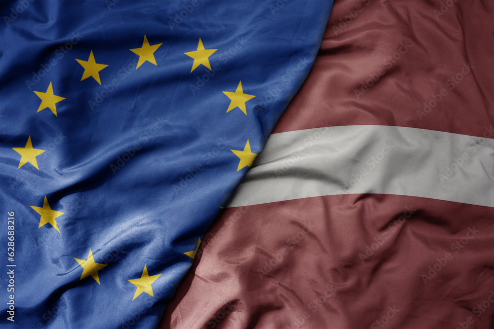 big waving realistic national colorful flag of european union and national flag of latvia . - obrazy, fototapety, plakaty 