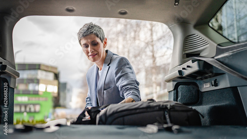 one senior woman pack luggage baggage suitcase in the trunk of the car © Miljan Živković
