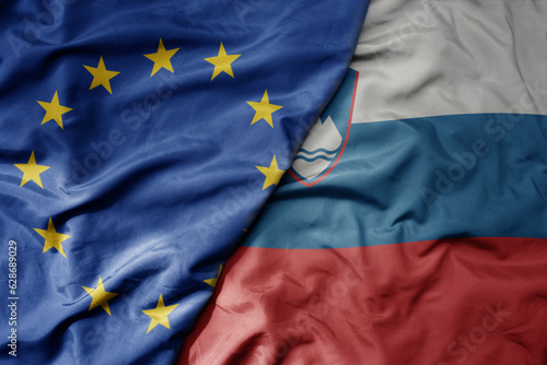 big waving realistic national colorful flag of european union and national flag of slovenia .