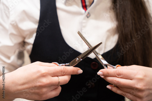 Craftswoman holds hairdressing scissors in her hands