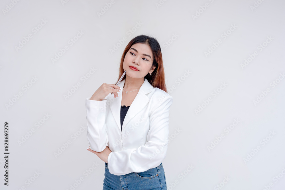 A serious young woman in deep thought while holding a pen towards her chin. Isolated on a white background. A serious young woman in deep thought while holding a pen towards her chin. Isolated on a white background.