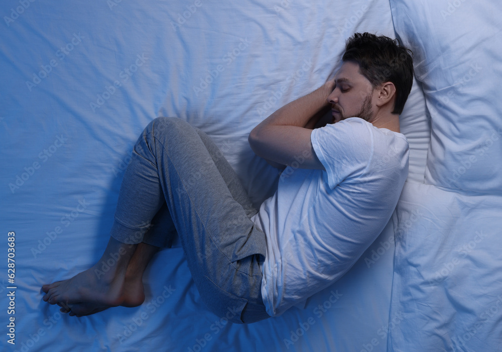 Man sleeping in bed at night, top view Man sleeping in bed at night, top view