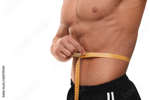 Athletic man measuring waist with tape on white background, closeup. Weight loss concept