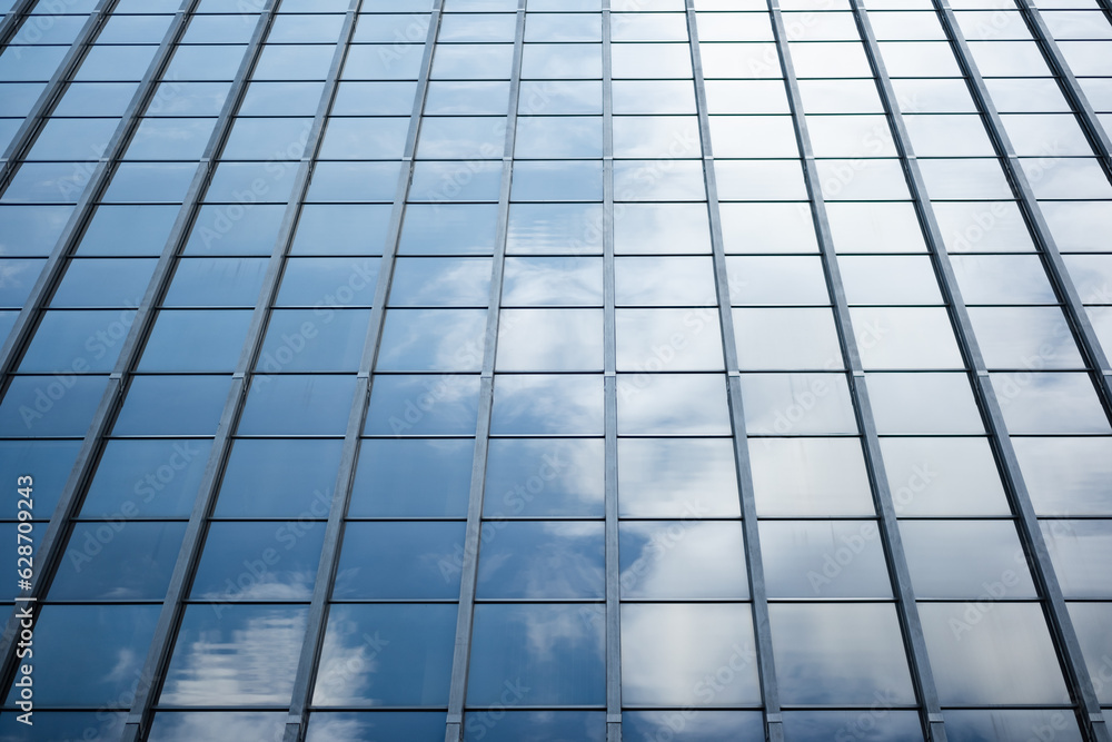Giving an example of converging in linear perspective, a neat grid of windows on a high-rise office building. The windows are mirrored, and reflect back a bright blue sky with clouds. Giving an example of converging in linear perspective, a neat grid of windows on a high-rise office building. The windows are mirrored, and reflect back a bright blue sky with clouds.