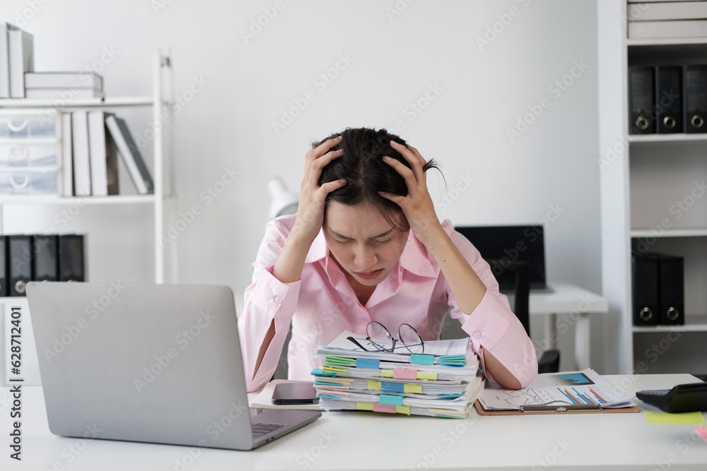 Tired and exhausted young Asian businesswoman feeling upset and lost focus after working for a loong hours. Tired and exhausted young Asian businesswoman feeling upset and lost focus after working for a loong hours.