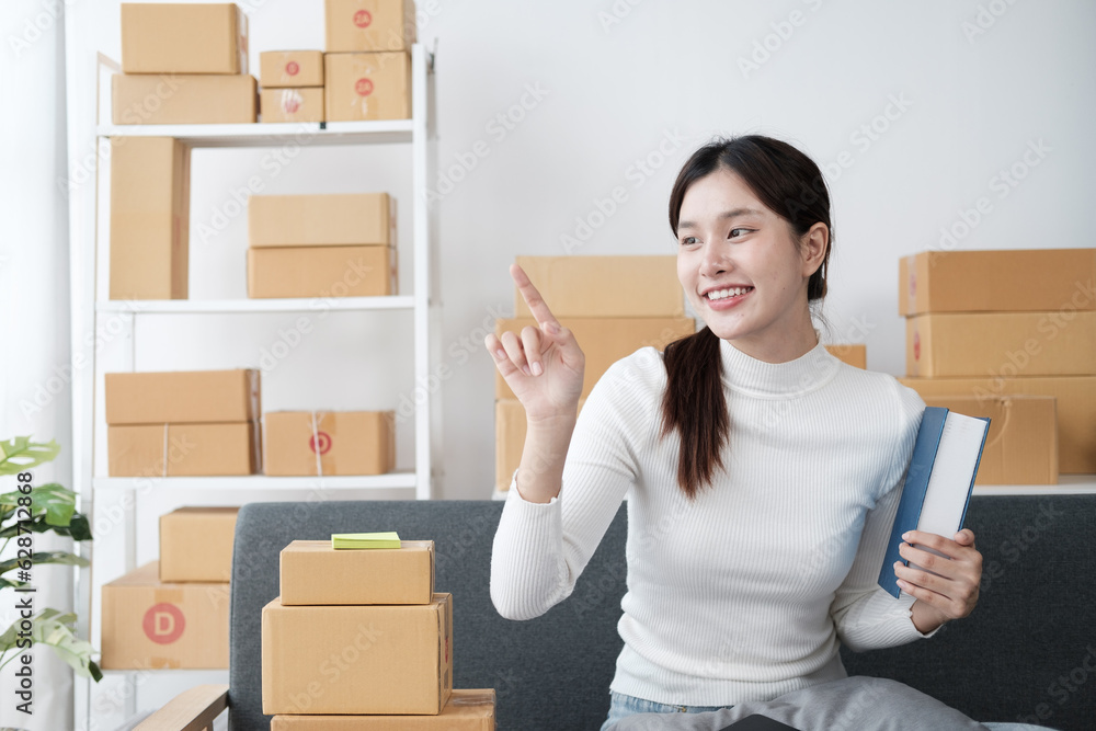 Young Asian women selling clothes online, streaming on social media with smartphone. Young Asian women selling clothes online, streaming on social media with smartphone.