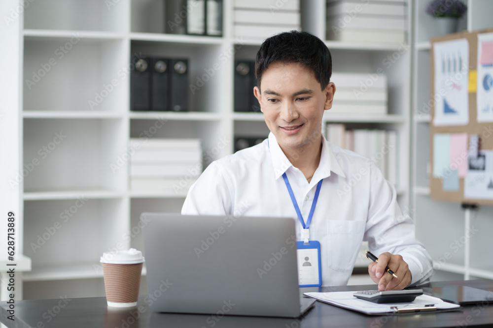 Young Asian businessman use digital calculator for tax, salary and personal expenses. Young Asian businessman use digital calculator for tax, salary and personal expenses.