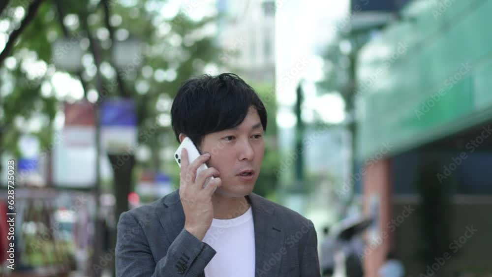 街中で電話する男性