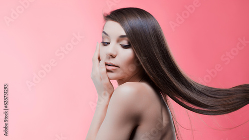 Beauty portrait of brunette with perfect hair, on a pink background