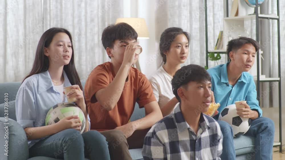Asian Teenagers Cheering, Eating And Watching Football Game On Tv At Home
Asian Teenagers Cheering, Eating And Watching Football Game On Tv At Home
