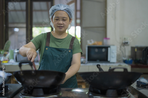Portrait of Asian woman chef cook in the kitchen, Countryside in Thailand.