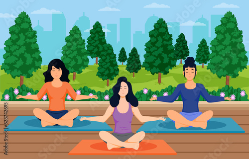 Group of people do yoga meditating together in the park