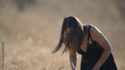 Bella Donna posa nel campo di grano con abito estivo video in 8K photo