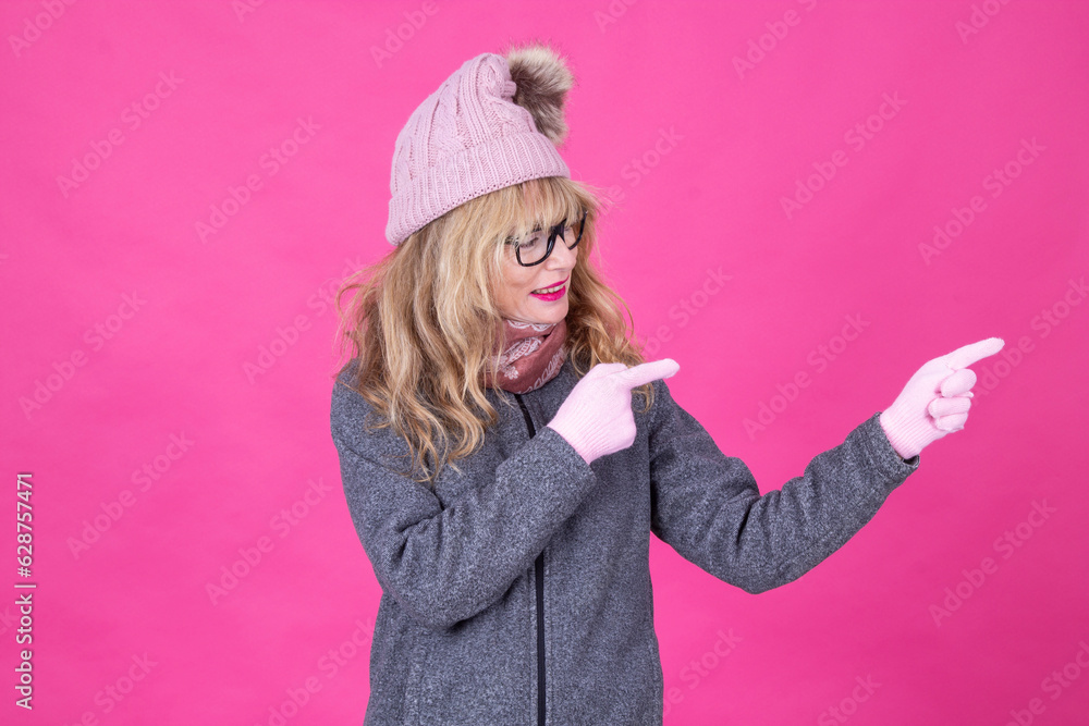 mature woman wearing winter clothes pointing or showing mature woman wearing winter clothes pointing or showing