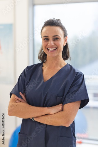 Free Download Portrait of happy female caucasian physiotherapist wearing scrubs at hospital - GFXLoad