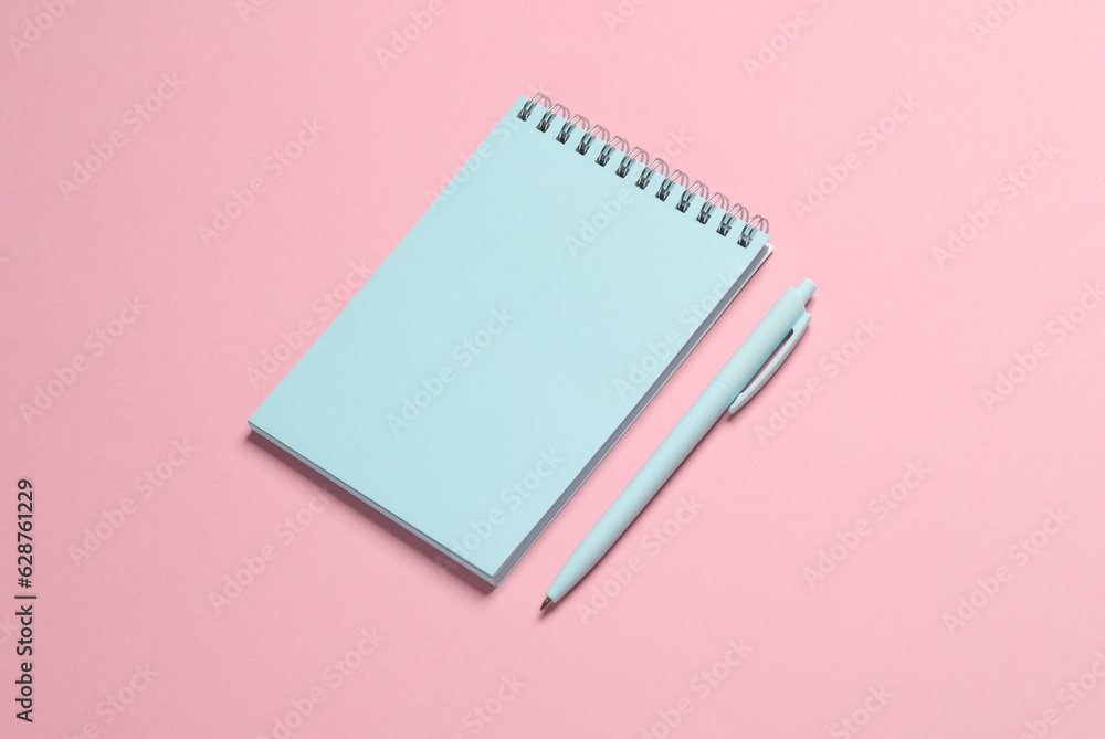 Blue notebook with a pen on pink background. Minimalism Blue notebook with a pen on pink background. Minimalism