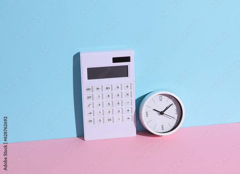 White calculator with clock on blue-pink background with shadow. Business and finance concept. Creative composition White calculator with clock on blue-pink background with shadow. Business and finance concept. Creative composition